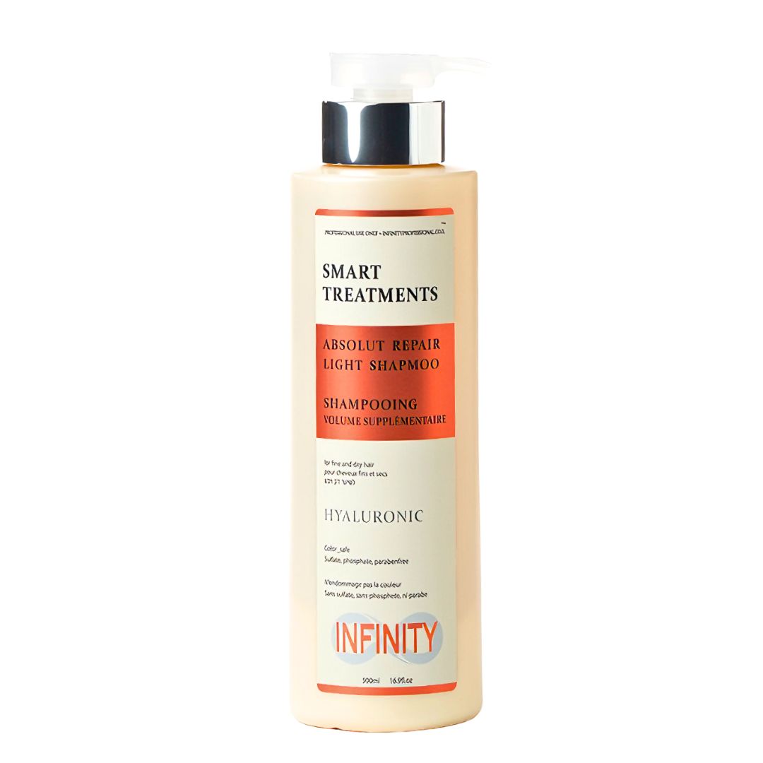 שמפו אינפינטי לייט 500 מ"ל SMART TREATMENTS ABSOLUT REPAIR עם מדבקה לבנה וכתומה, גוף בקבוק בצבע שמנת-כתוםבהיר ופקק כסוף על רקע לבן